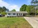 Charming single-story home features a well-manicured front lawn, welcoming facade, and carport at 1238 Moss Springs Rd, Albemarle, NC 28001