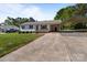 Inviting home featuring a covered front porch, adjacent car port, and lush lawn at 1238 Moss Springs Rd, Albemarle, NC 28001