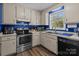 Classic kitchen features white cabinets, stainless steel appliances, and a view to the outdoors at 1238 Moss Springs Rd, Albemarle, NC 28001