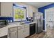 Functional kitchen featuring stainless steel appliances, blue accent wall, and backyard view at 1238 Moss Springs Rd, Albemarle, NC 28001