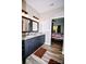 Modern bathroom with dual sinks, granite countertops, and wood-look floors at 129 Devon Dr, Heath Springs, SC 29058