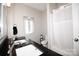 Bright bathroom with dual sinks, dark countertops, and a shower-tub combo at 129 Devon Dr, Heath Springs, SC 29058