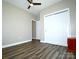 Bedroom with hardwood style floors, ceiling fan, closet with sliding doors, and white trim at 129 Devon Dr, Heath Springs, SC 29058