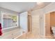 Bright bathroom featuring a large soaking tub with a window and separate walk-in shower at 13817 Kings Carriage Ln, Charlotte, NC 28278