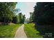 Serene lakefront community amenity featuring a walking path leading to scenic water views at 13817 Kings Carriage Ln, Charlotte, NC 28278
