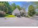Well-maintained home featuring a manicured lawn, attached garage, and lush greenery at 13817 Kings Carriage Ln, Charlotte, NC 28278