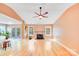 Spacious living room featuring hardwood floors, a ceiling fan, and a cozy fireplace at 13817 Kings Carriage Ln, Charlotte, NC 28278