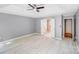 Spacious main bedroom with tray ceiling, wood floors, a fan and an open doorway to the bathroom at 13817 Kings Carriage Ln, Charlotte, NC 28278