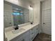 Bright bathroom boasts double sinks with quartz countertops, black hardware, a large mirror, and a tiled shower at 142 Prestwick Way # 18, Mooresville, NC 28115