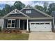 Charming craftsman-style home featuring a two-car garage, stone accents, and eye-catching gable details at 142 Prestwick Way # 18, Mooresville, NC 28115