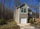 New construction two-story home with tan siding and one-car garage on a treed lot at 148 Kodak Dr, Statesville, NC 28625