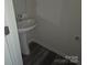 Modern powder room featuring sleek pedestal sink and stylish wood-look flooring at 149 Kodak Dr, Statesville, NC 28625