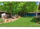 Grassy backyard showcasing trees, an outdoor seating area, and storage shed at 1501 Briarfield Dr, Charlotte, NC 28205