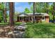 Charming brick home with a well-manicured lawn and inviting walkway, nestled among mature trees at 1501 Briarfield Dr, Charlotte, NC 28205
