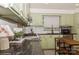Updated kitchen featuring tile backsplash, modern appliances, granite countertops, and light green cabinetry at 1501 Briarfield Dr, Charlotte, NC 28205