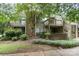 Two-story exterior showing brick and siding and balcony access on a tree-filled corner lot at 1600 Sharon W Rd # 8, Charlotte, NC 28210