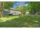 Expansive backyard with lush lawn, mature trees, and home exterior featuring a fenced yard, ideal for outdoor activities at 16614 Beech Hill Dr, Huntersville, NC 28078