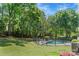 Lush backyard with a fenced in-ground pool surrounded by trees and lawn, with comfortable seating area and umbrella at 16614 Beech Hill Dr, Huntersville, NC 28078