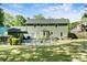 Backyard view featuring a sparkling in-ground pool with a black fence, grassy area and view of the home's exterior at 16614 Beech Hill Dr, Huntersville, NC 28078