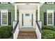 Welcoming front porch with detailed railings, a brick entryway, and sconce lighting at 16614 Beech Hill Dr, Huntersville, NC 28078