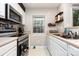 A modern kitchen with stainless steel appliances, white cabinets, and a window providing natural light at 1766 Forest Side Ln, Charlotte, NC 28213