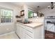 A well-lit kitchen featuring white cabinetry, neutral countertops, and a double basin sink under a window at 1766 Forest Side Ln, Charlotte, NC 28213