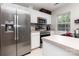 A spacious kitchen with stainless steel refrigerator and microwave, white cabinets, and a light countertop at 1766 Forest Side Ln, Charlotte, NC 28213