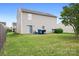 View of a backyard with a sliding door entry to the home and two trashcans, a grill, and chairs on a concrete slab at 1849 Meadow Crossing Dr # 118, Huntersville, NC 28078