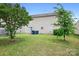 View of a backyard with a sliding door entry to the home and two trashcans, a grill, and chairs on a concrete slab at 1849 Meadow Crossing Dr # 118, Huntersville, NC 28078