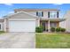 Charming two-story home featuring a two-car garage, stone accents, and a well-maintained front lawn at 1849 Meadow Crossing Dr # 118, Huntersville, NC 28078