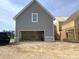 Spacious garage attached to a gray two-story house with a brick foundation at 19044 Newburg Hill Rd, Davidson, NC 28036