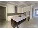 Unfinished, spacious kitchen features a large island, white cabinets, herringbone backsplash, and modern design ready for customization at 19044 Newburg Hill Rd, Davidson, NC 28036