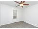 The empty bedroom features neutral carpet, white walls, a ceiling fan and a window providing ample natural light at 2068 Samantha Dr, Kannapolis, NC 28083