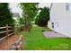 Tranquil backyard with a stone retaining wall, wooden fence, and mature trees, creating a private outdoor oasis at 2624 St Helena Ct, Fort Mill, SC 29715
