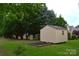 Well-maintained shed in a spacious backyard, surrounded by lush greenery and a garden bed, perfect for storage or hobbies at 2624 St Helena Ct, Fort Mill, SC 29715