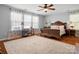 This bedroom features an ornate wood bed, a ceiling fan, and an area rug on hardwood floors at 281 Loch Stone St, Fort Mill, SC 29715