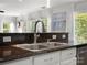 This kitchen boasts a stainless steel sink with gooseneck faucet, solid surface counters, and natural light at 281 Loch Stone St, Fort Mill, SC 29715