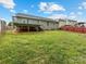 Grassy backyard featuring an elevated deck, bordered by a wooden fence at 3022 Willamette Valley Dr, Charlotte, NC 28215