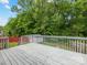A spacious wooden deck with a gray railing offers a perfect view of the backyard and surrounding trees at 3022 Willamette Valley Dr, Charlotte, NC 28215