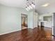 Bright dining room with modern lighting, hardwood floors, access to the kitchen, and a view of adjacent living spaces at 3022 Willamette Valley Dr, Charlotte, NC 28215