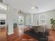 Bright dining room features a sleek modern light fixture, a stylish oval table with seating for six, and hardwood floors at 3022 Willamette Valley Dr, Charlotte, NC 28215