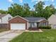 Charming single-story home with brick accents, a two-car garage, and a cozy front porch with rocking chairs at 3022 Willamette Valley Dr, Charlotte, NC 28215