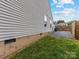 Shows the side of this home featuring vinyl siding, foundation with air vents, and gravel landscaping at 3022 Willamette Valley Dr, Charlotte, NC 28215