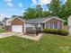 Charming single-story home with brick accents, a wooden deck, an attached two-car garage, and a well-maintained lawn at 3022 Willamette Valley Dr, Charlotte, NC 28215