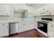 Bright kitchen featuring white cabinets, stainless steel appliances, a serving pass-through, and dark wood floors at 3022 Willamette Valley Dr, Charlotte, NC 28215