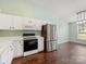 Open kitchen with white cabinetry, stainless steel appliances, modern lighting, and wood flooring at 3022 Willamette Valley Dr, Charlotte, NC 28215