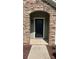 Close up of the front door with stone archway, a black door with glass panes, and a stylish exterior light at 3030 Collin House Dr, Fort Mill, SC 29715