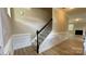 Bright foyer with staircase featuring wood floors, white wainscoting, and a black handrail, open to living area at 3030 Collin House Dr, Fort Mill, SC 29715