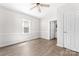 Bright bedroom with wood-look floors, a large window, and doorway visible to another room at 3117 Fraley Church Rd, Gastonia, NC 28054
