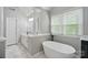 Bright bathroom boasts a soaking tub, double vanity, and marble floors at 3908 Brittany Ct, Indian Trail, NC 28079